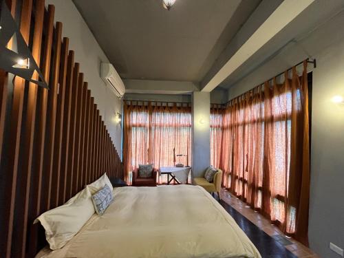 una camera da letto con un letto grande e finestre di 6號交響曲民宿 a Chenggong