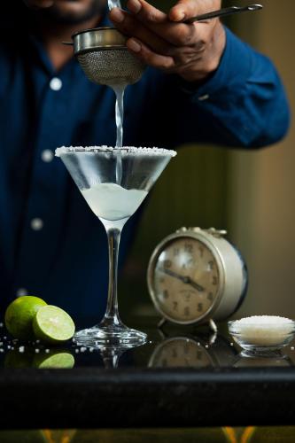 a person is mixing a martini in a martini glass at La baga Beach Hotel in Calangute