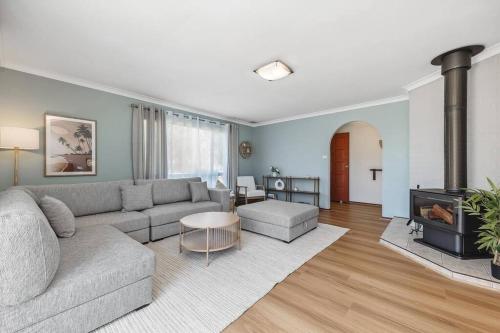 a living room with a couch and a fireplace at Sea La Vie ~ Pet Friendly Coastal Chic Broadwater Retreat in Broadwater