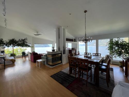 uma cozinha e sala de estar com mesa e cadeiras em Pacific Gem em West Vancouver