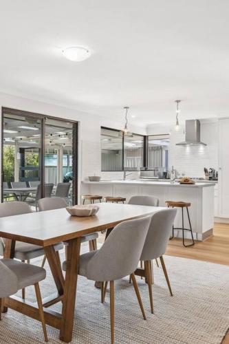a dining room and kitchen with a table and chairs at Sea La Vie ~ Pet Friendly Coastal Chic Broadwater Retreat in Broadwater
