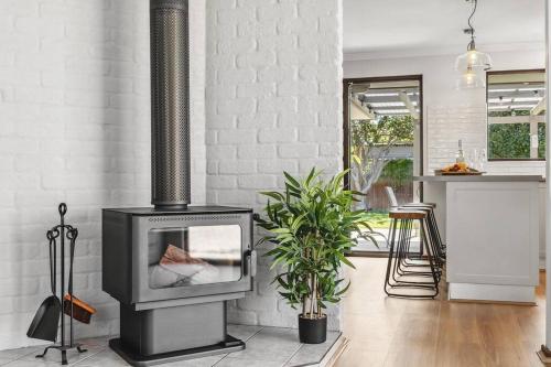 a fireplace in a living room with a plant at Sea La Vie ~ Pet Friendly Coastal Chic Broadwater Retreat in Broadwater