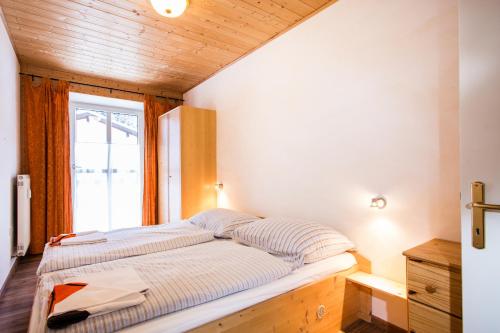 a bed in a room with a window at Appartment 1500 m an der Seilbahnstation in Uttendorf