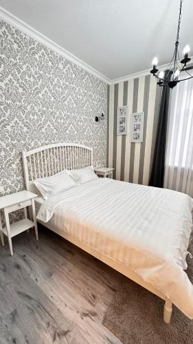 a bedroom with a large white bed in a room at DOWNTOWN APPARTMENTS in Karagandy