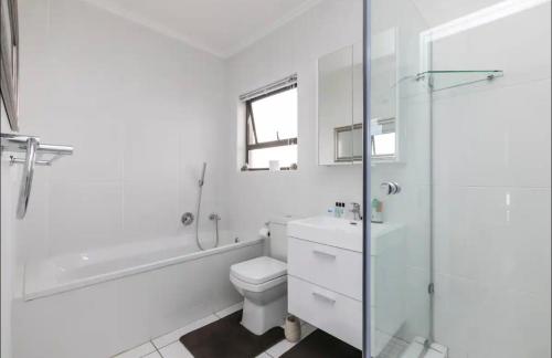 a white bathroom with a toilet and a shower at Place to remember in Sandton