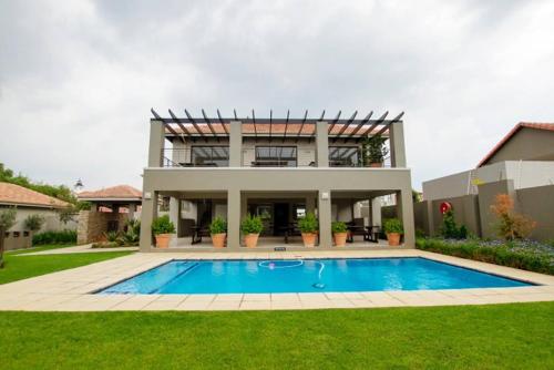 a house with a swimming pool in front of a house at Place to remember in Sandton