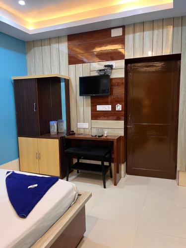 a bedroom with a desk and a bed and a desk at Hotel Holiday Home in Digha