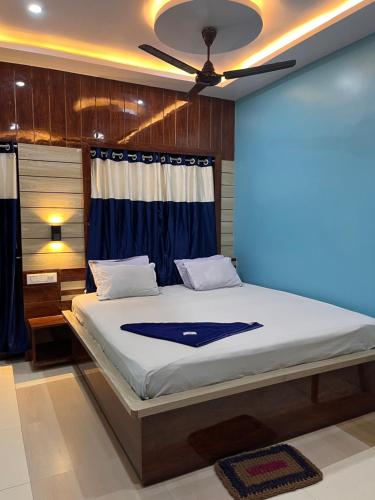 um quarto com uma cama grande e uma ventoinha de tecto em Hotel Holiday Home em Digha