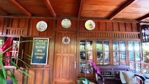 a room with wooden walls with plates on the wall at rumah kayu sulawesi antique in Bedugul