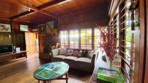 a living room with a couch and a table at rumah kayu sulawesi antique in Bedugul