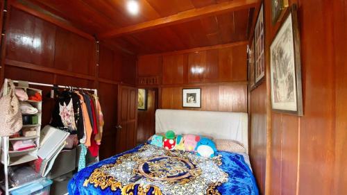 a bedroom with a bed in a room with wooden walls at rumah kayu sulawesi antique in Bedugul