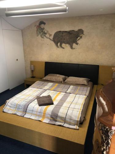 a bedroom with a bed with a bear on the wall at Bedroom cum office with shared shower in Zug's Old Town in Zug