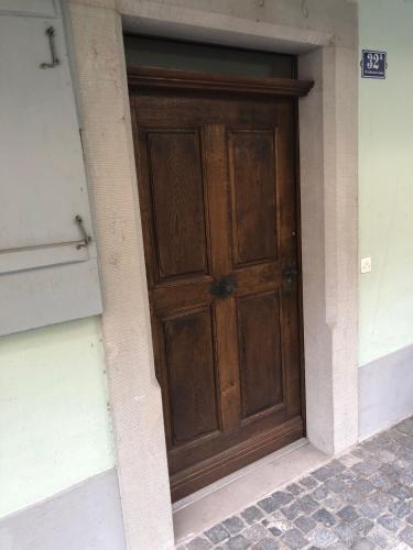 a wooden door on the side of a building at Bedroom cum office with shared shower in Zug's Old Town in Zug