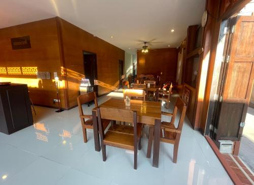 a dining room with a wooden table and chairs at เวลาและนาที Wella&Natee in Chiang Khan