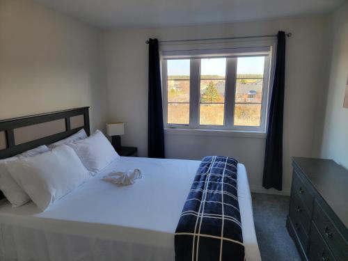 um quarto com uma grande cama branca e uma janela em Chorburjo Cozy Villa - Two Rooms em Penetanguishene