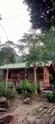 a wooden house with a tree in front of it at สามชุกบ้านสวน in Sam Chuk