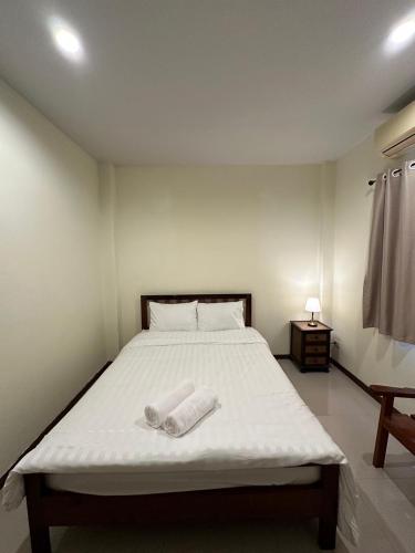 a bedroom with a bed with two towels on it at เวลาและนาที Wella&Natee in Chiang Khan