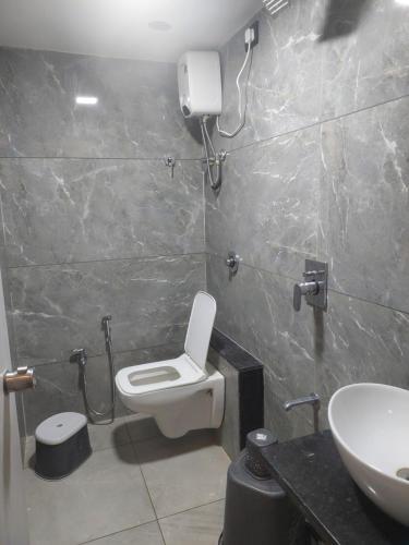 a bathroom with a toilet and a sink at HOTEL R K VILLA in Ahmedabad