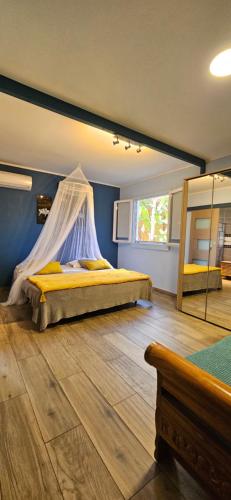 Schlafzimmer mit einem Bett mit Moskitonetz in der Unterkunft Villa YSANGA in Saint-Pierre