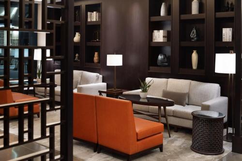 a living room with a couch and tables and shelves at JW Marriott Hotel Muscat in Muscat