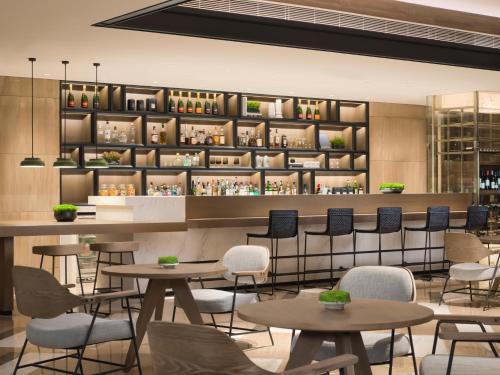a restaurant with tables and chairs and shelves with wine bottles at Sheraton Guangzhou Hotel in Guangzhou