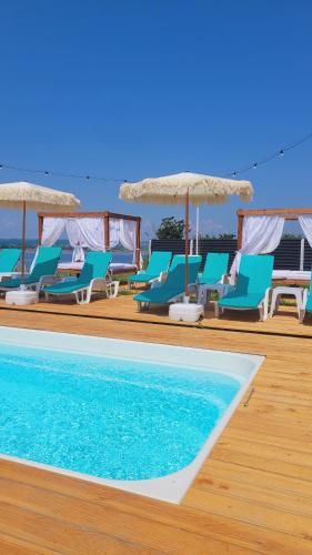 een groep blauwe stoelen en een zwembad bij Breeze By The Lake - Cazare cu jacuzzi pe malul lacului 