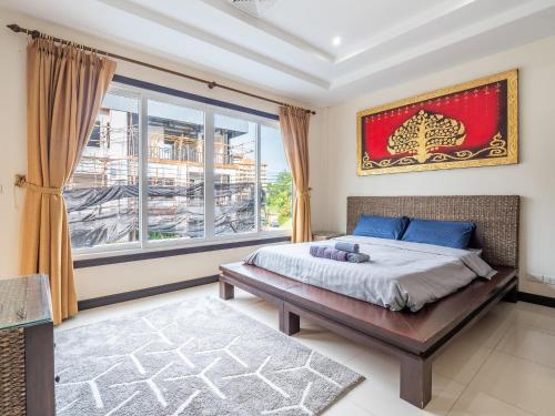 1 dormitorio con cama y ventana grande en 长住优惠-芭提雅市中心6卧泳池别墅，近海滩，网红美人鱼餐厅，悬崖餐厅 en Pattaya South