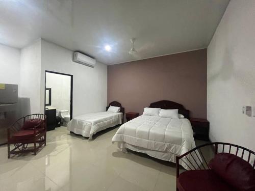 エラドゥーラにあるCabinas El Anzuelo #1のベッド2台と鏡が備わるホテルルームです。
