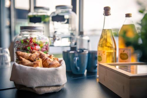 a bowl of food on a table with a bottle of oil at JOST Hôtel Le Havre Centre Gare in Le Havre