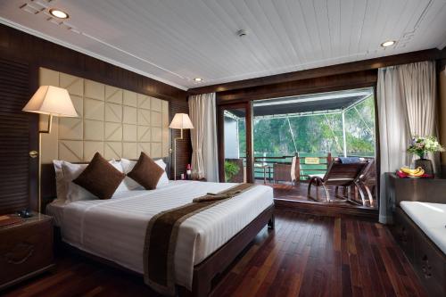 ein Schlafzimmer mit einem großen Bett und einem Balkon in der Unterkunft Mila Cruises in Hạ Long