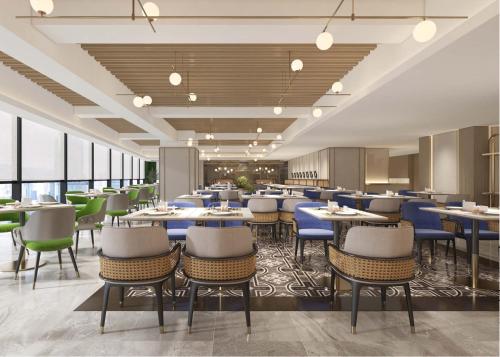 a restaurant with blue tables and chairs and windows at Hilton Garden Inn Wuhan Hankou in Wuhan
