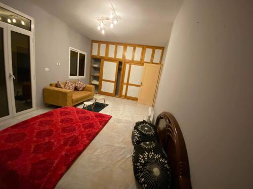 - un salon avec un tapis rouge et un canapé dans l'établissement S+2 Corniche Nord, à Bizerte