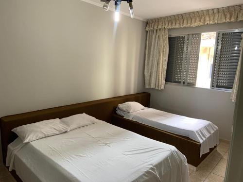 a bedroom with two beds and a window at Casa Gomes in Praia Grande