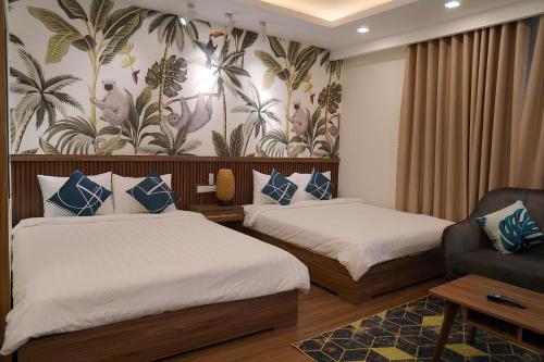 a hotel room with two beds and a couch at FLC Sea Tower Condotel in Quy Nhon