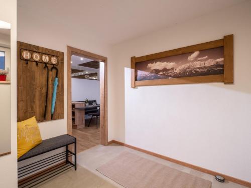 a hallway with a bench and a wall with a painting at Appartement Torblick in Ellmau