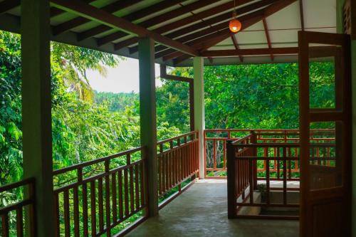 a porch of a house with a view of the forest at Yino Villa Midigama in Midigama