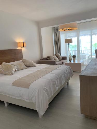 a bedroom with a large bed and a living room at Le Clos des Bains Mauritius in Blue Bay