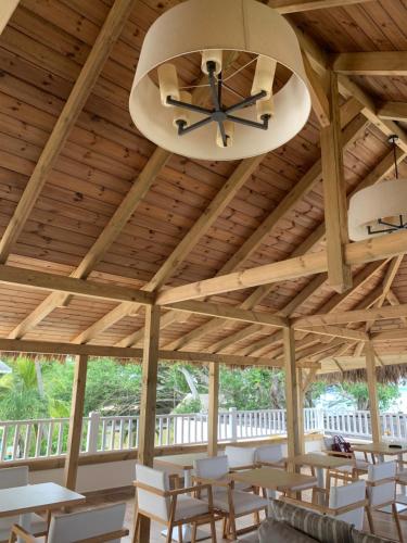 a large wooden pavilion with white chairs and a ceiling at Le Clos des Bains Mauritius in Blue Bay