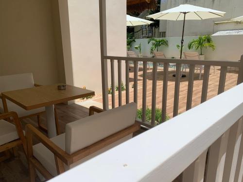 a balcony with a table and chairs and an umbrella at Le Clos des Bains Mauritius in Blue Bay