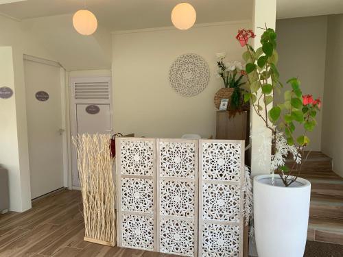 a room with white dividers and a vase with a plant at Le Clos des Bains Mauritius in Blue Bay
