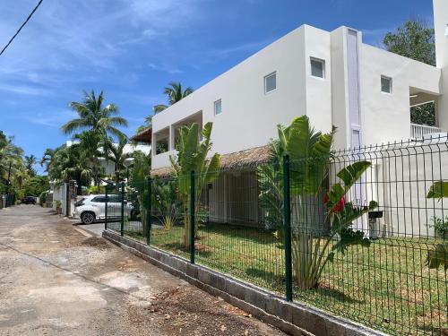 a white house with a fence in front of it at Le Clos des Bains Mauritius in Blue Bay