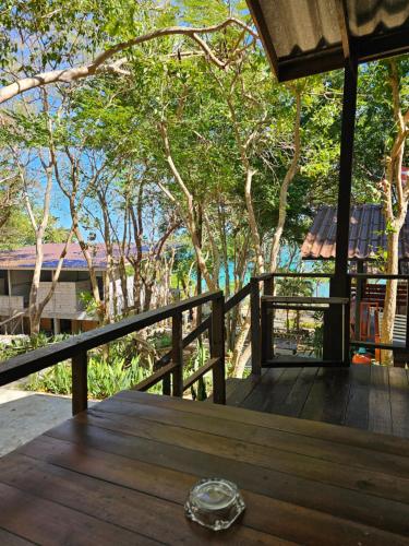 een houten tafel op een balkon met bomen op de achtergrond bij Horizon Resort in Ko Samed