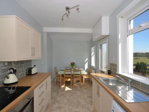 a kitchen with a table and a dining room at Criffel View in Dumfries