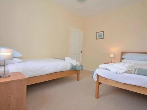 um quarto com 2 camas e uma mesa com 2 candeeiros em Criffel View em Dumfries