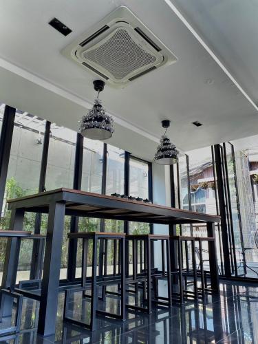 a table in a room with chairs and windows at NANEE Phra Singh in Chiang Mai