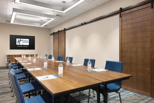 a conference room with a long table and chairs and a screen at Holiday Inn Express Cape Canaveral by IHG in Cape Canaveral