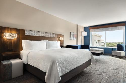 a hotel room with a bed and a large window at Holiday Inn Express Cape Canaveral by IHG in Cape Canaveral