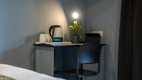 a table with a blender and a chair in a room at Sortby Stays, Vagator in Vagator