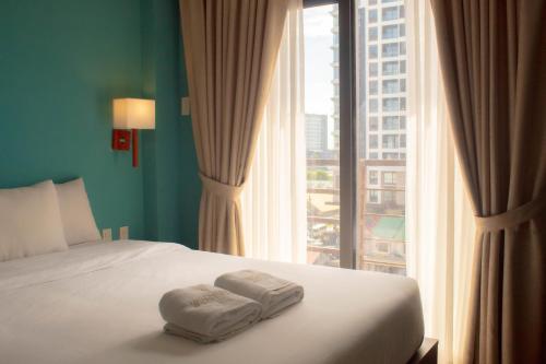 a bedroom with a bed and a large window at Valentino's Hotel in Angeles