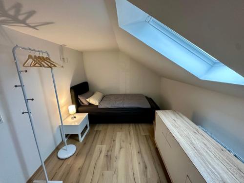 niewielka sypialnia z łóżkiem i oknem dachowym w obiekcie Schöne, helle Ferienwohnung in Lünen Mitte ! w mieście Lünen